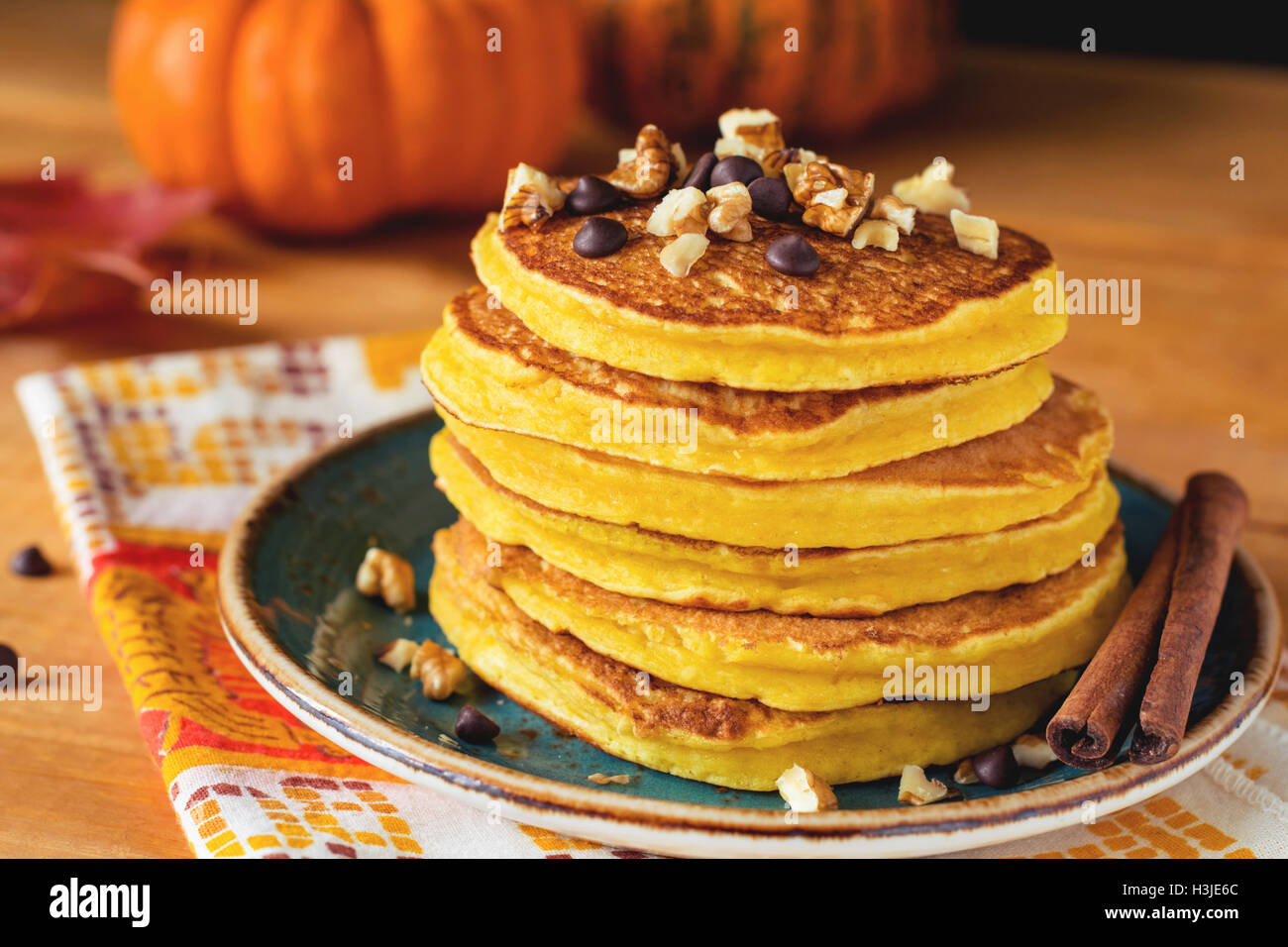Pumpkin pancakes with nuts and chocolate on plate. Close up. Autumn breakfast meal, traditional American cuisine Stock Photo
