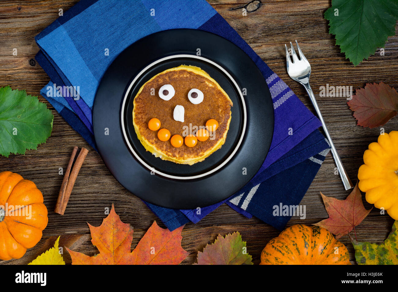 Halloween pumpkin pancake with funny face made with candies and