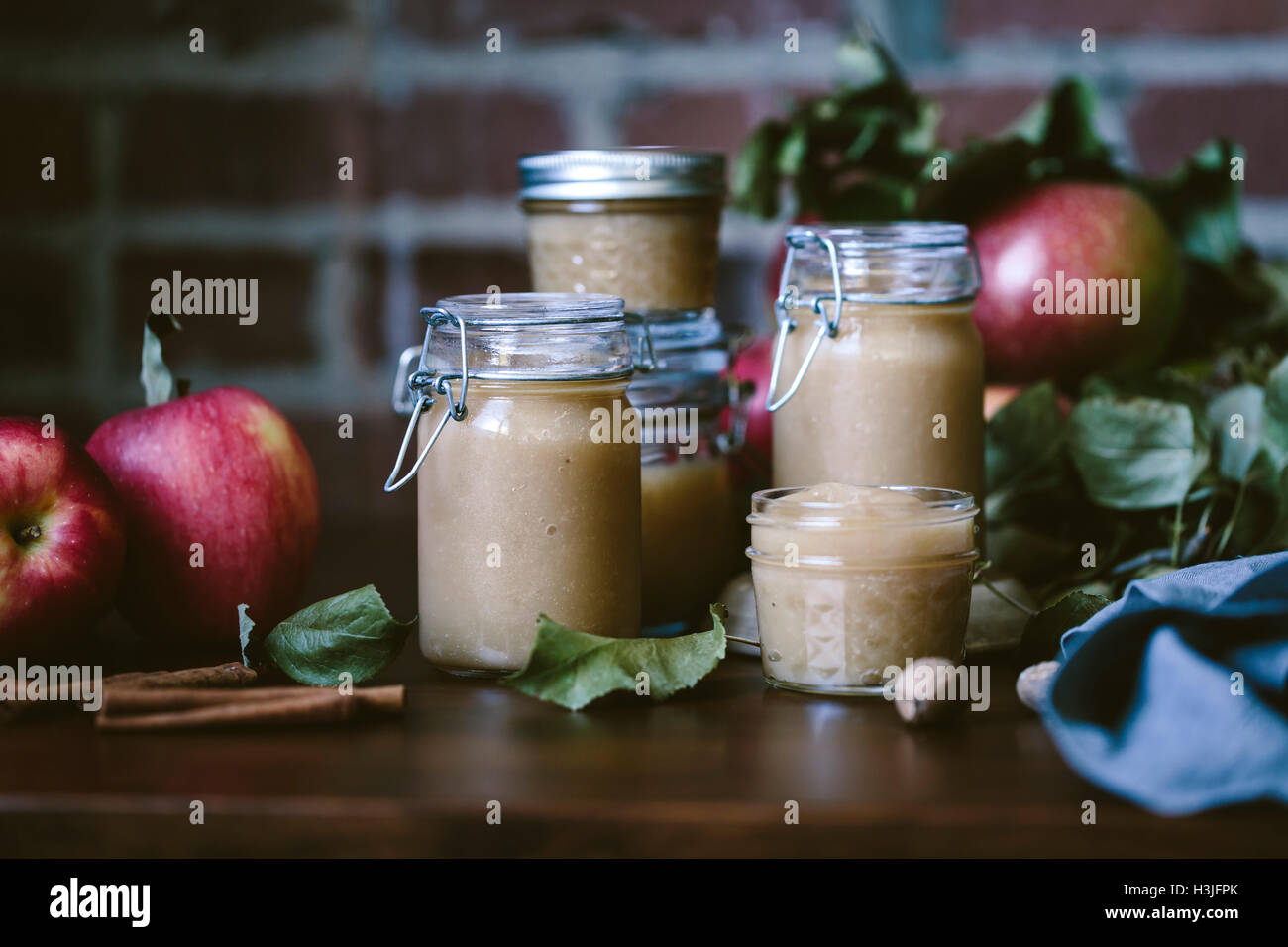 Glass jars filled with homemade slow cooker applesauce are photographed