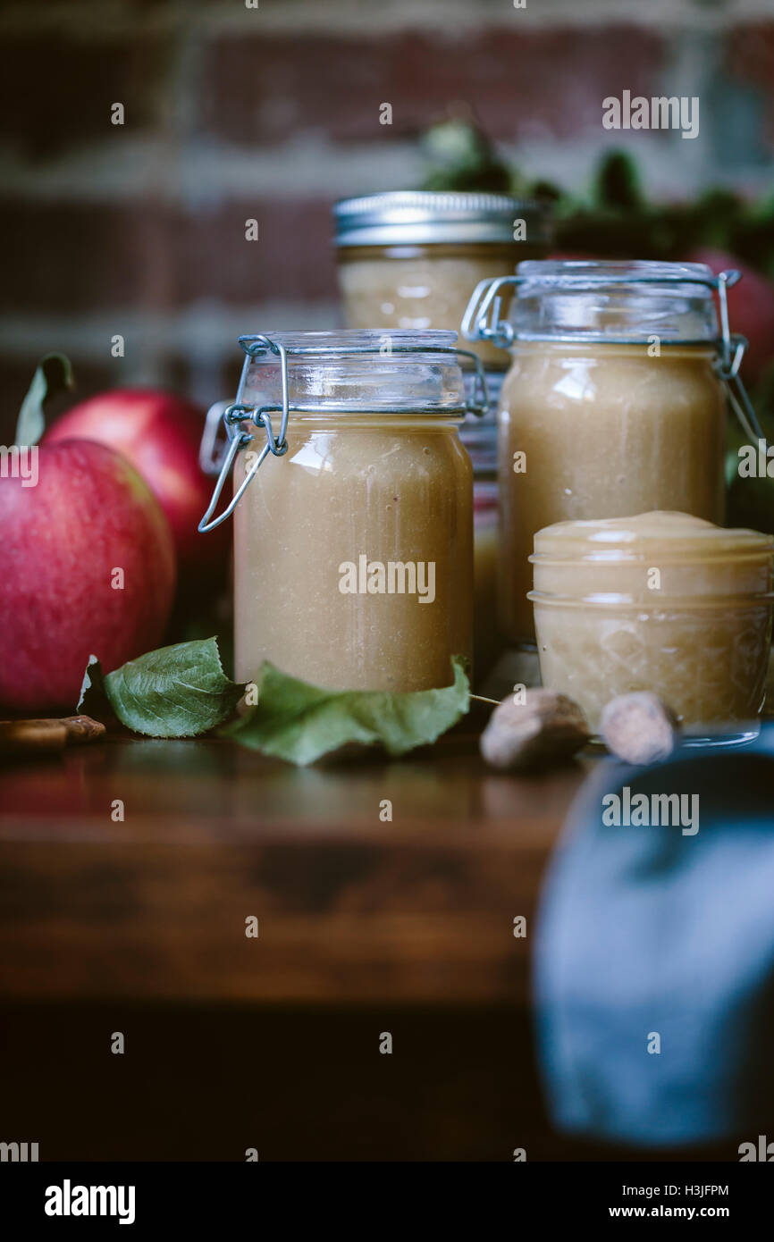 Glass jars filled with homemade slow cooker applesauce are photographed
