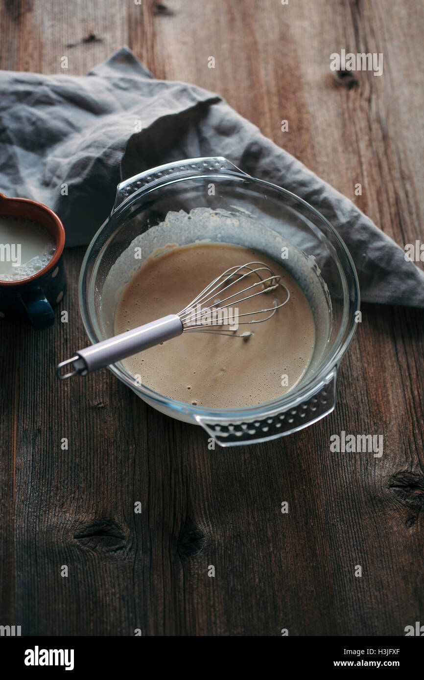 Eggs, sugar, milk, flour batter in a glass bowl on rustic wooden table Stock Photo Alamy