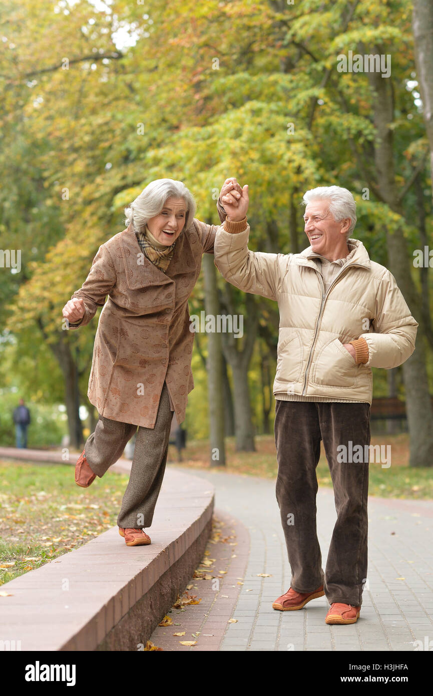 Beautiful elderly couple walking in the autumn park Stock Photo - Alamy