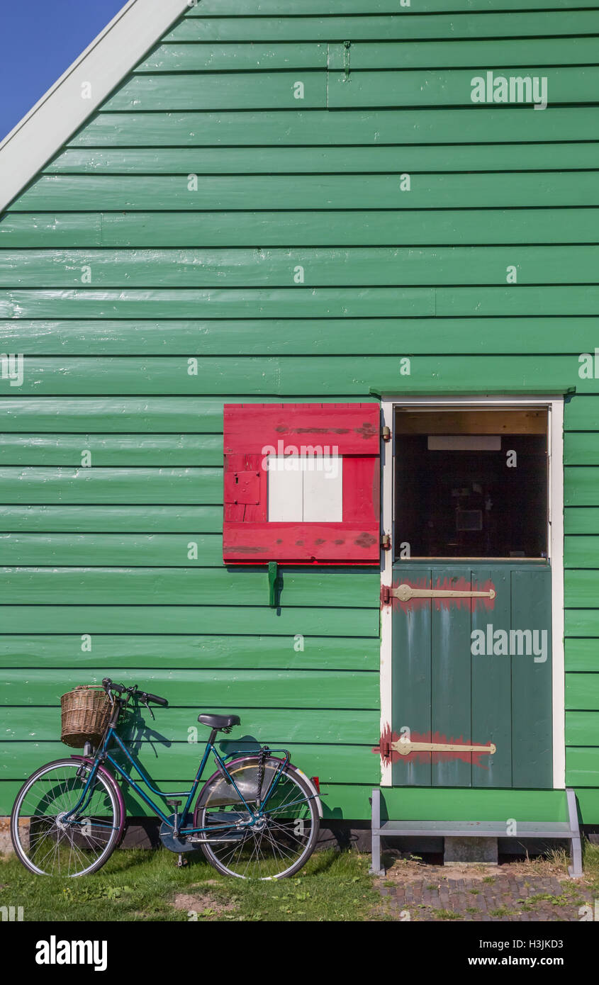 Bicycle in front of a green wooden house in Zaanse Schans, Netherlands Stock Photo