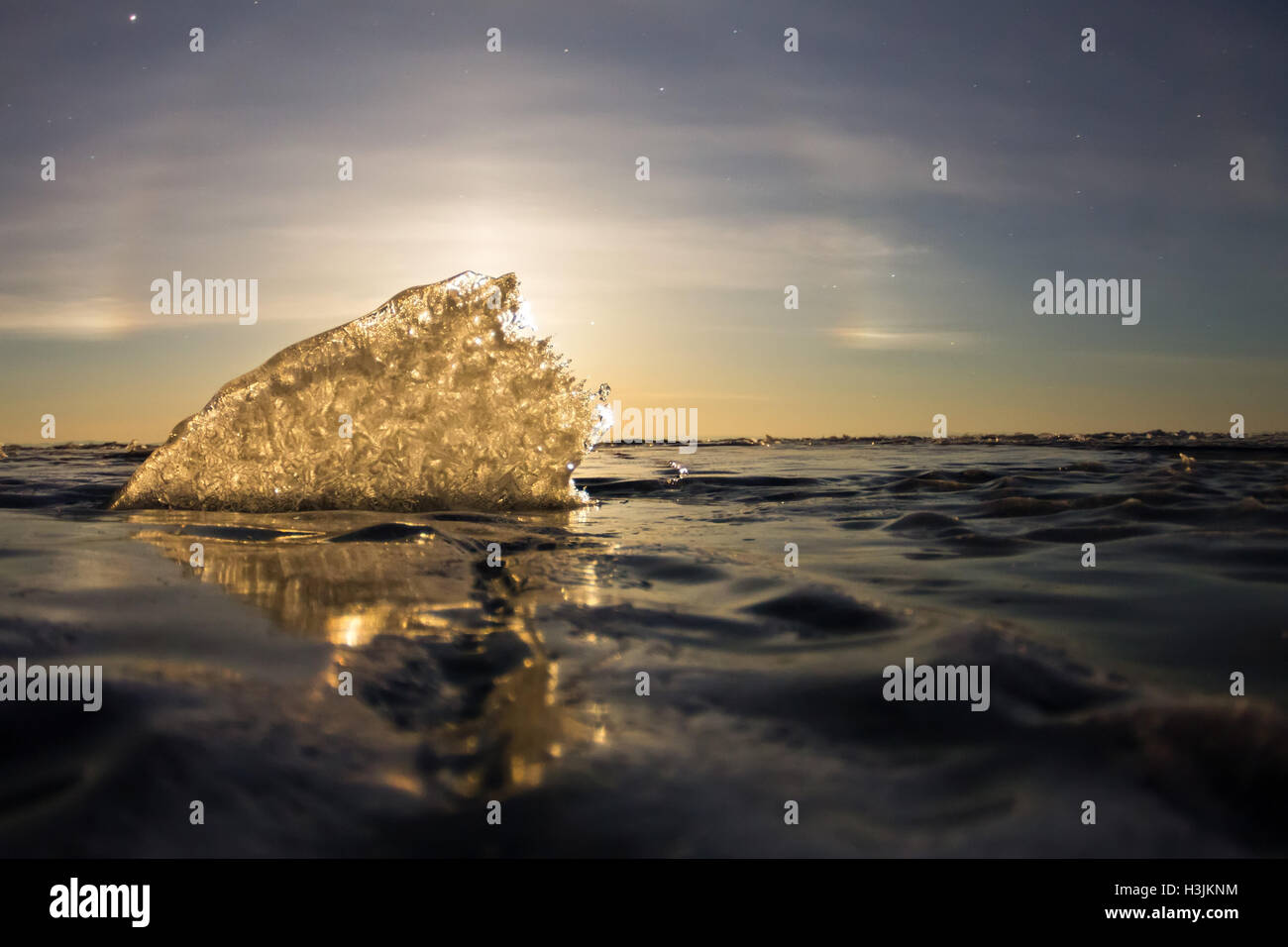 A lunar halo shining through the transparent ice ridge, Olkhon island ...