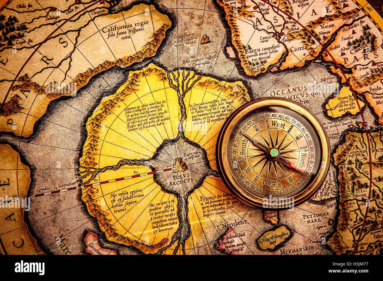 Vintage still life. Vintage compass lies on on the ancient map of the North Pole (also Hyperborea).. Arctic continent on the Ger Stock Photo