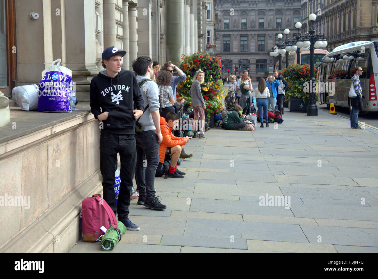 Festival goers in George Square Glasgow prepare to board buses to T in the park pop festival and carry all they need for the wee Stock Photo