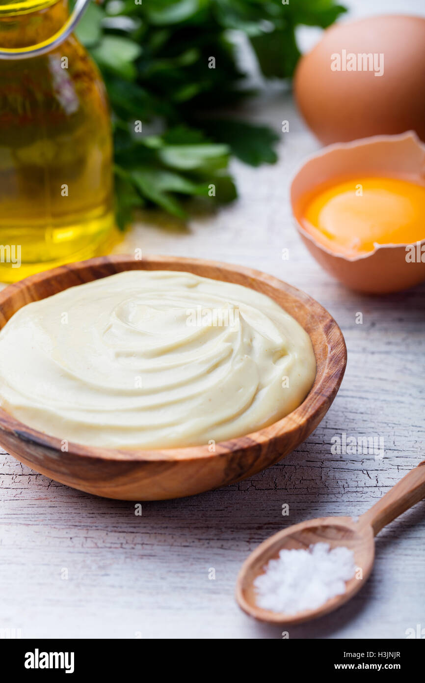 Homemade mayonnaise, mayo in a wooden bowl. White background Stock