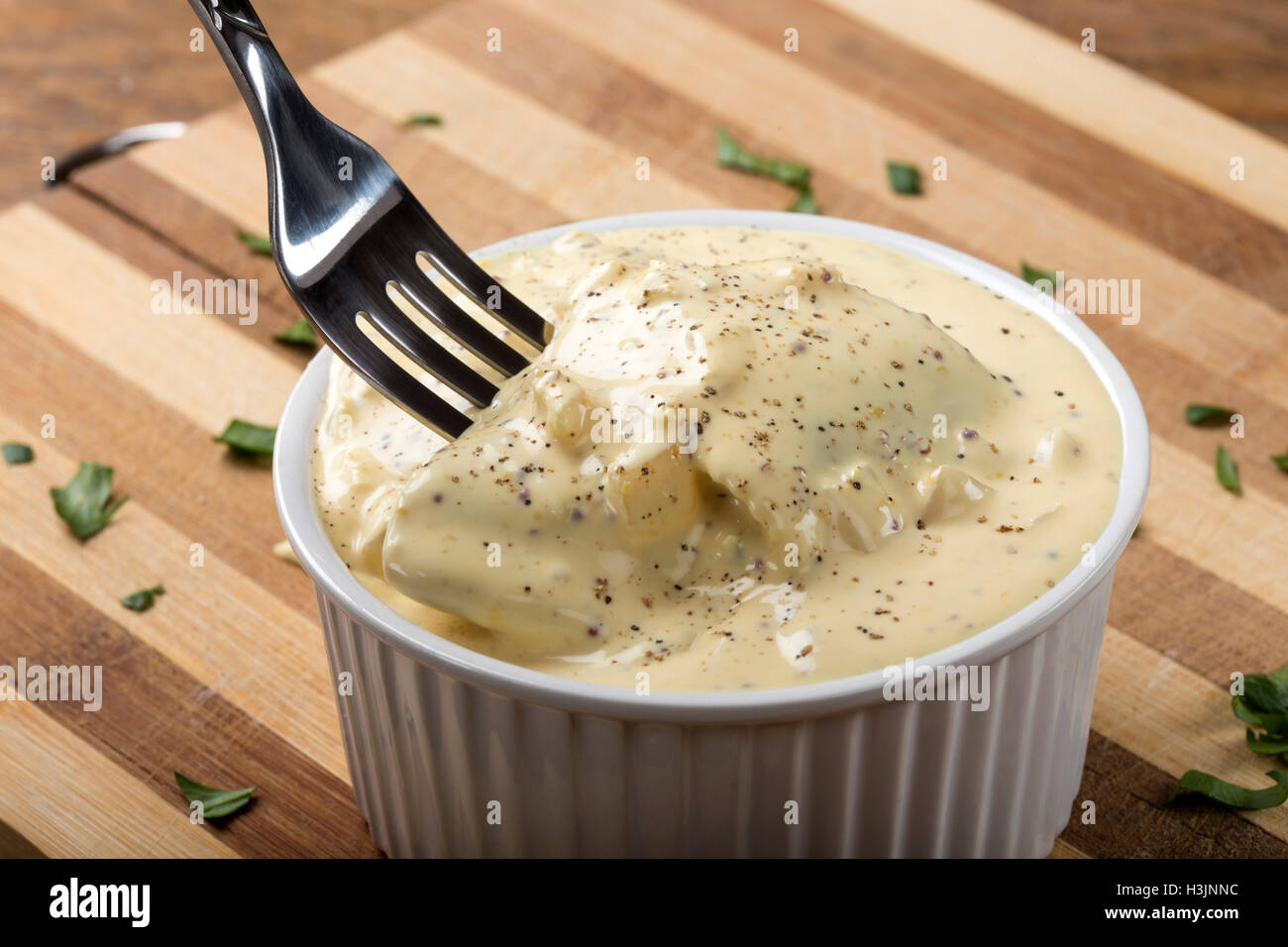 Bowl with herring fillets in mustard sauce and fork Stock Photo Alamy