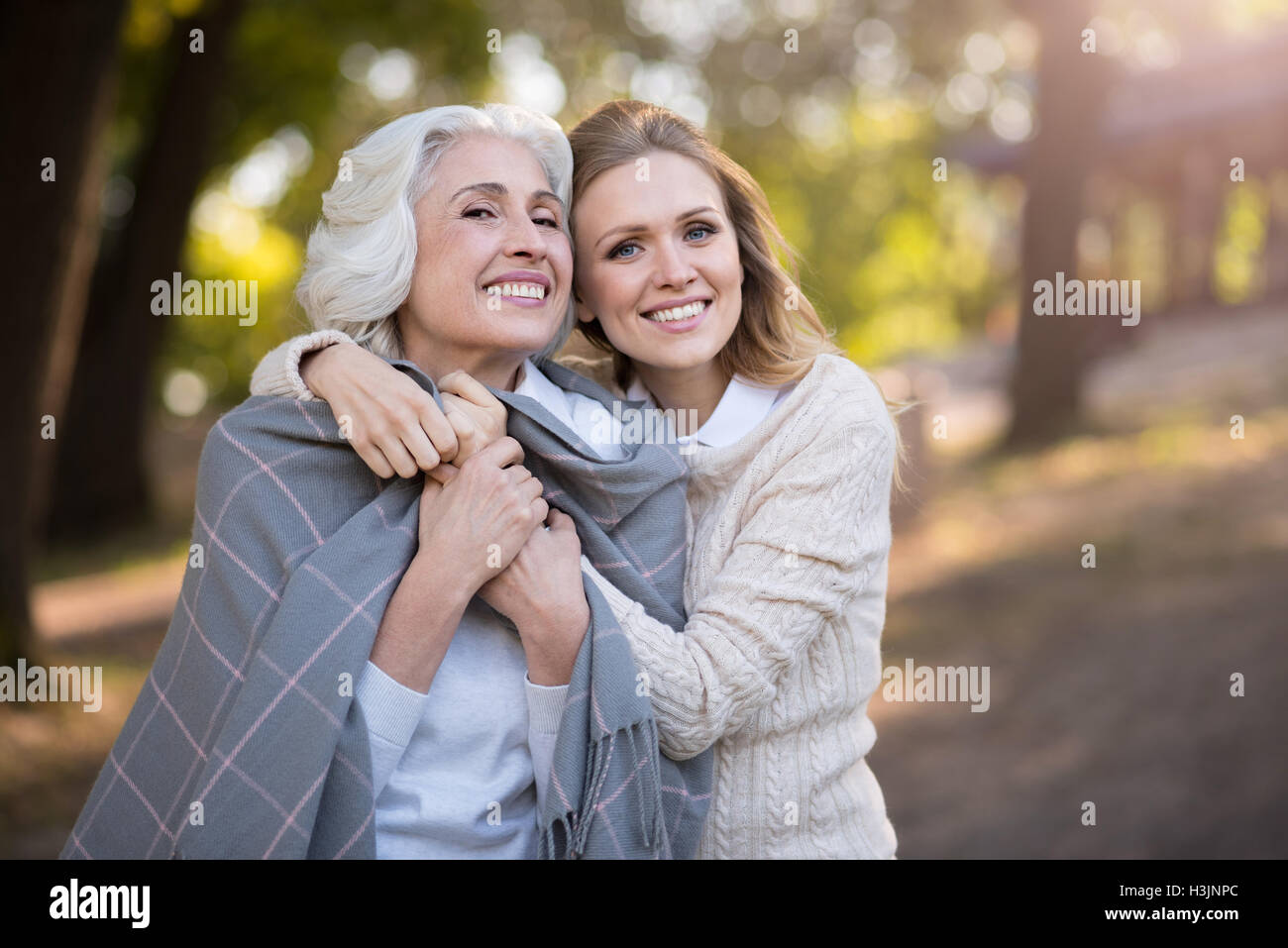 Two cheerful beautiful women smiling and hugging Stock Photo - Alamy