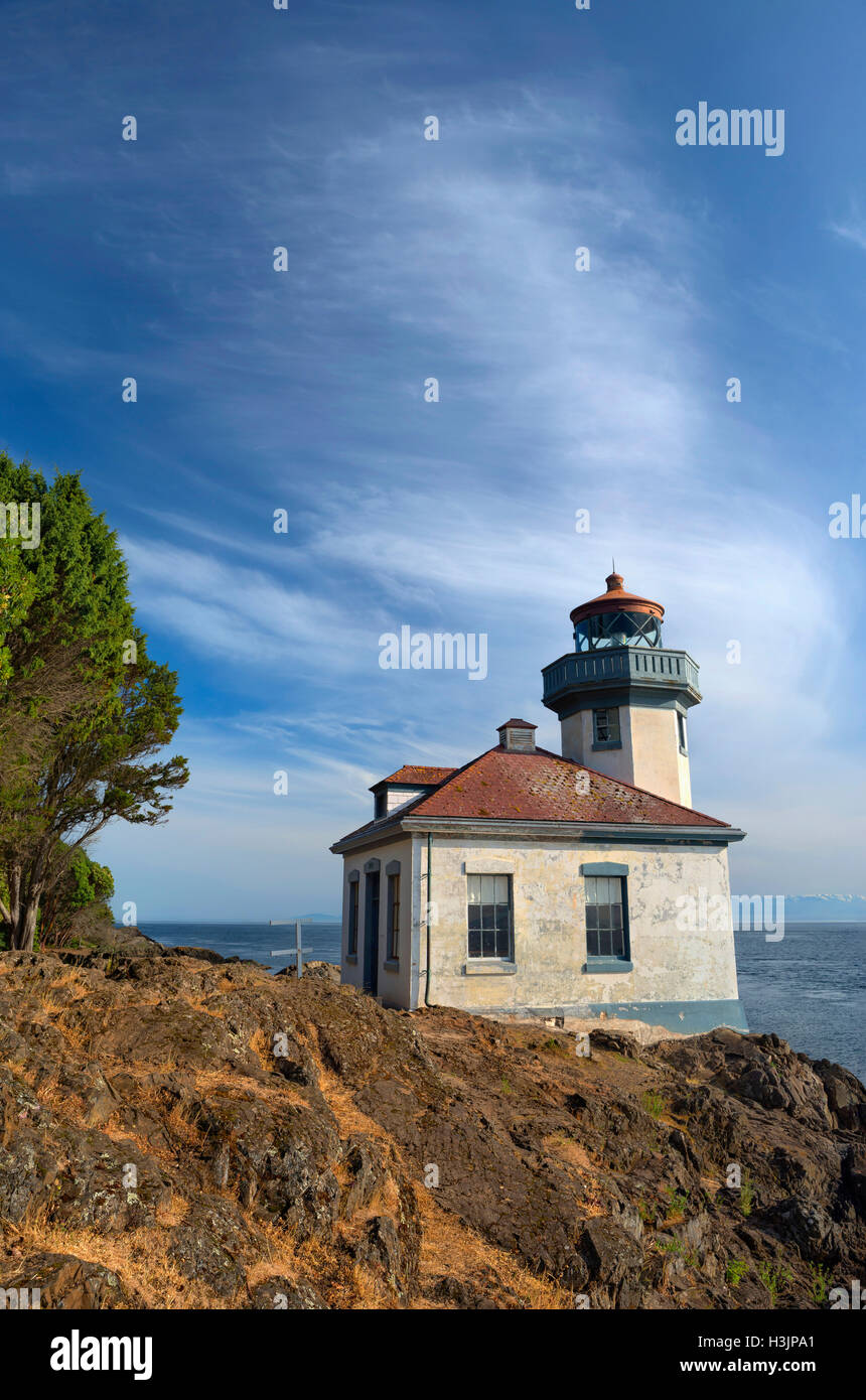 USA, Washington, San Juan Island, Lime Kiln Point State Park, Lime Kiln Point Lighthouse and shoreline beneath a cloudy sky. Stock Photo