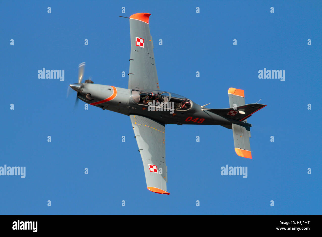 Military aircraft. Polish Air Force PZL-130 Orlik single engine propeller powered trainer plane flying in a blue sky at an air display Stock Photo