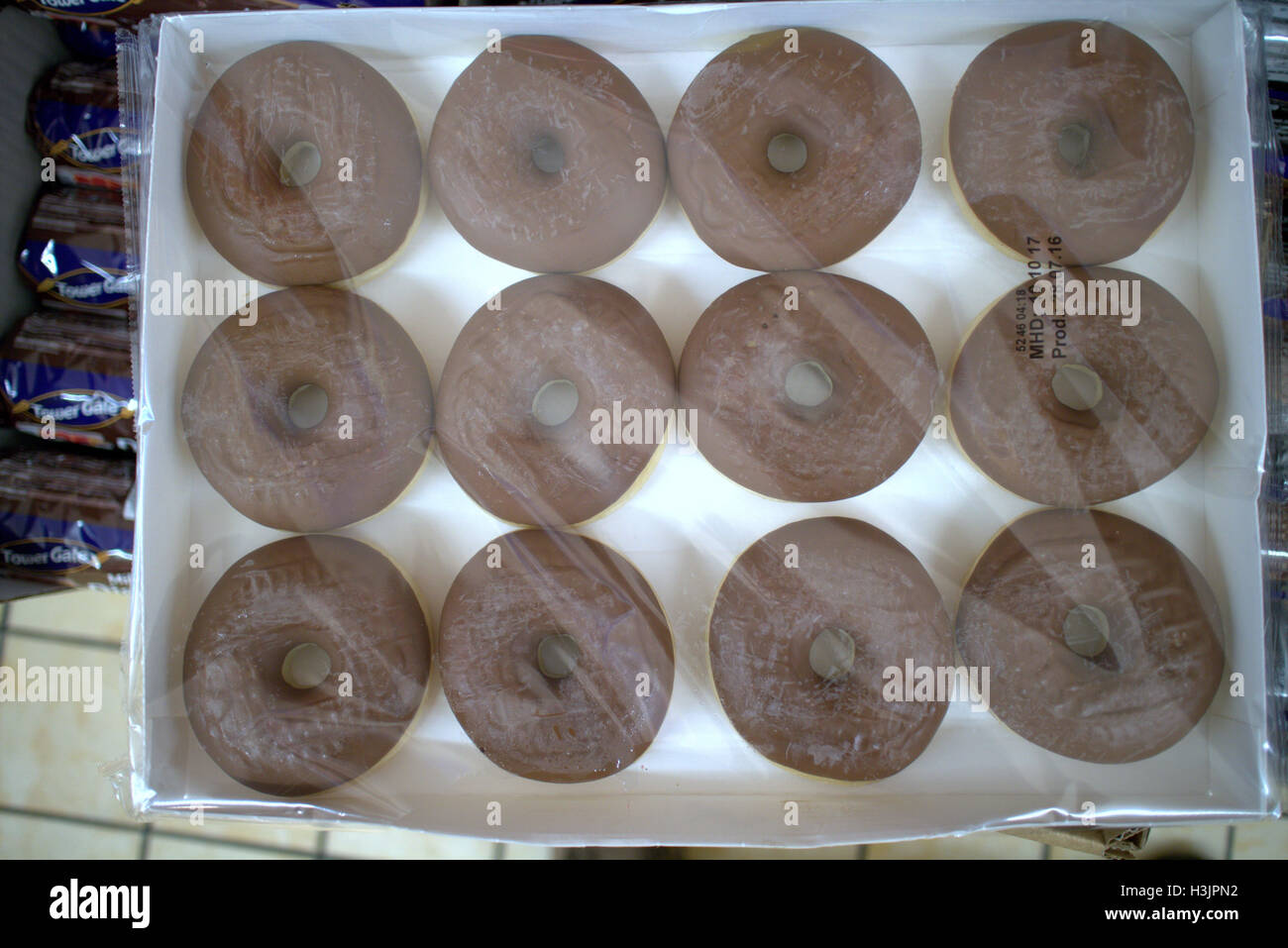 Boxed  dozen chocolate dough rings, dough nuts in cellophane wrapping unbranded, Stock Photo