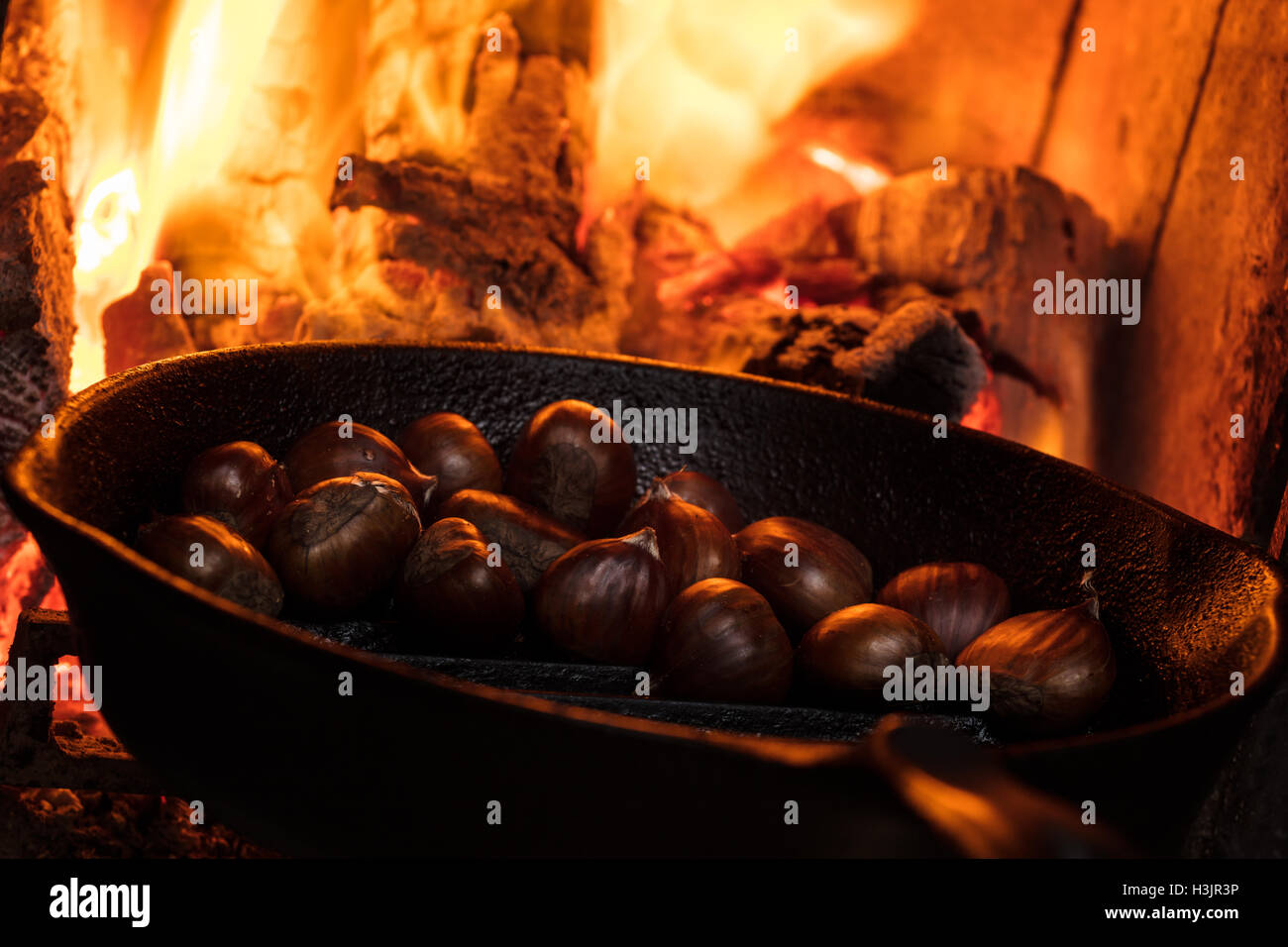 Roasted chestnut in frying pan on black stone background Stock Photo - Alamy