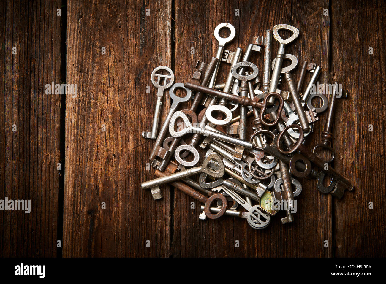 Pile of antique keys on a grunge wooden background Stock Photo - Alamy