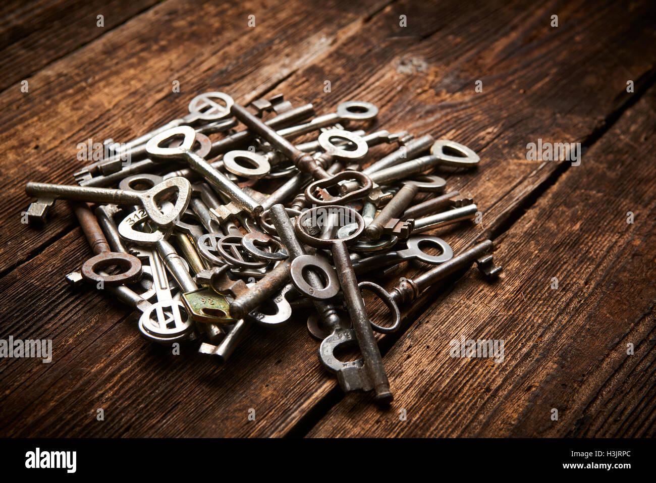 Pile of antique keys on a grunge wooden background Stock Photo - Alamy