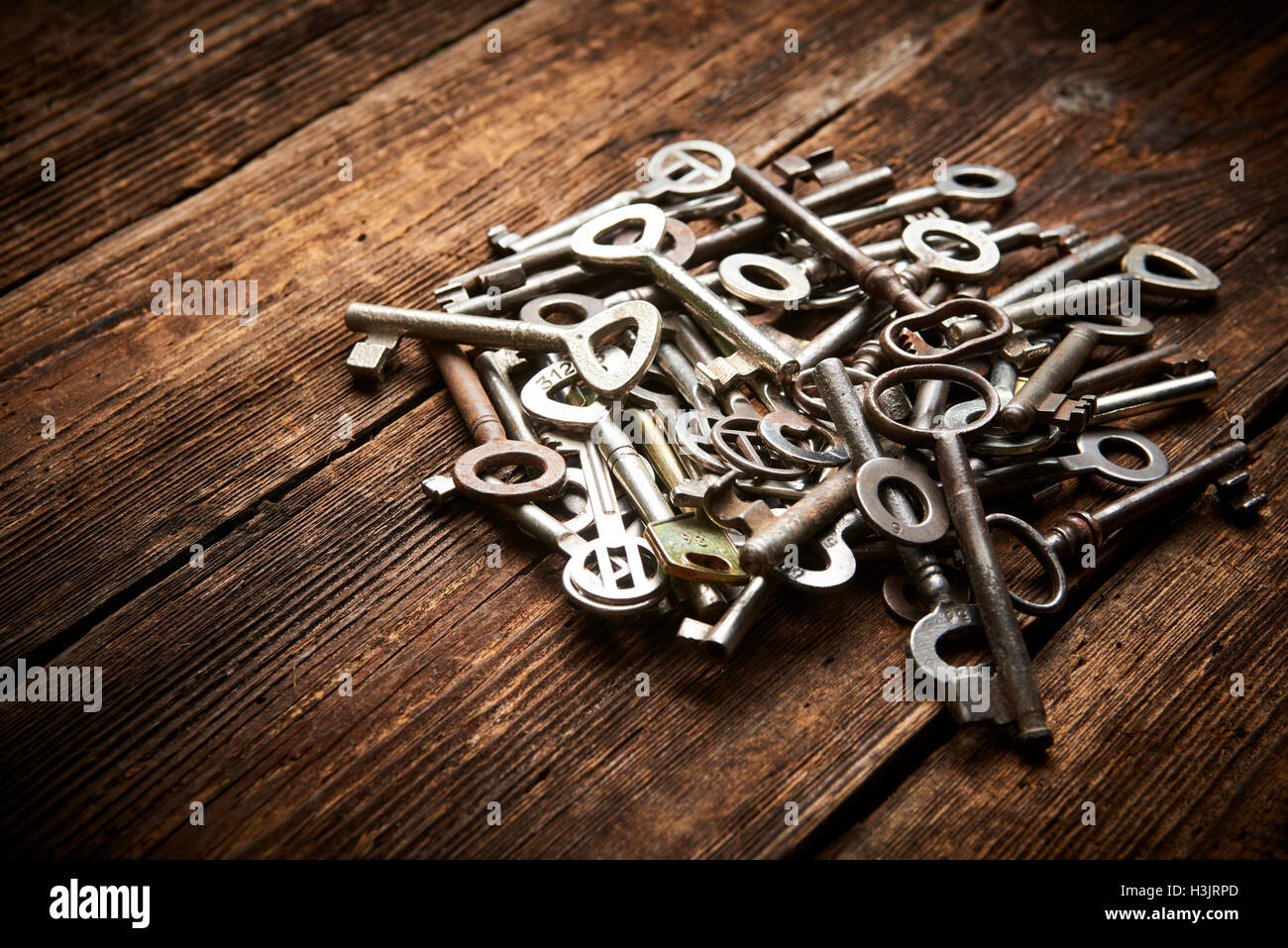 Pile of antique keys on a grunge wooden background Stock Photo - Alamy