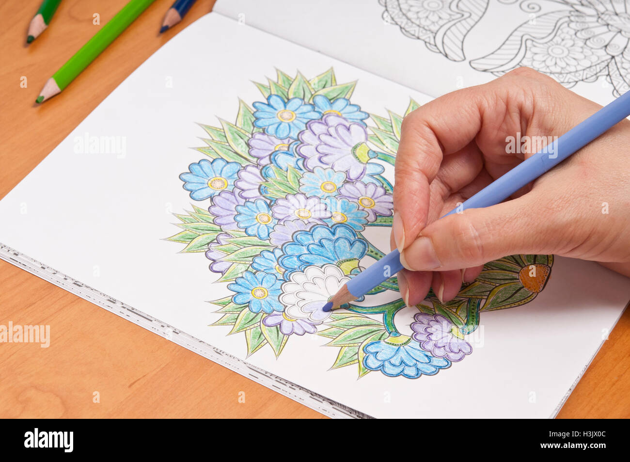 woman working on a colouring book for adults Stock Photo