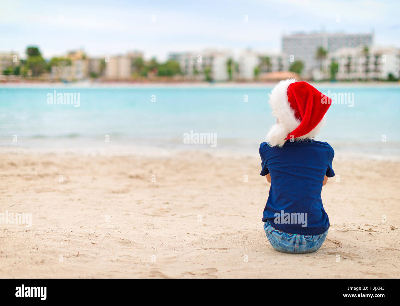 Funny little girl sitting on the beach. Christmas and new year vacations concept Stock Photo Alamy