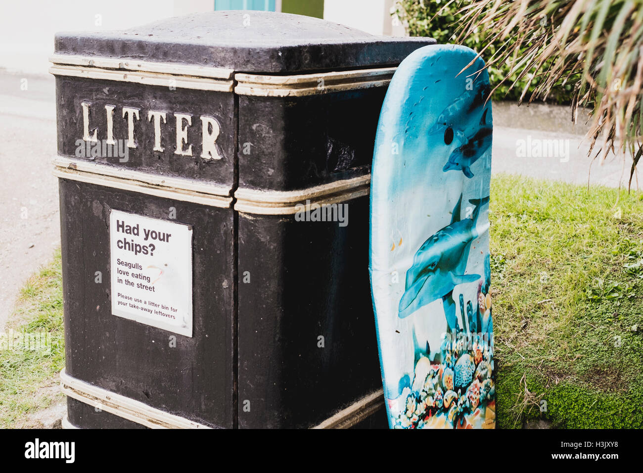 An abandoned body board propped up against a litter bin at Falmouth beach. Stock Photo