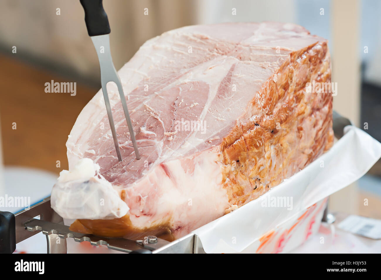 Close up of italian cooked ham ready to be sliced . Selective focus. Stock Photo