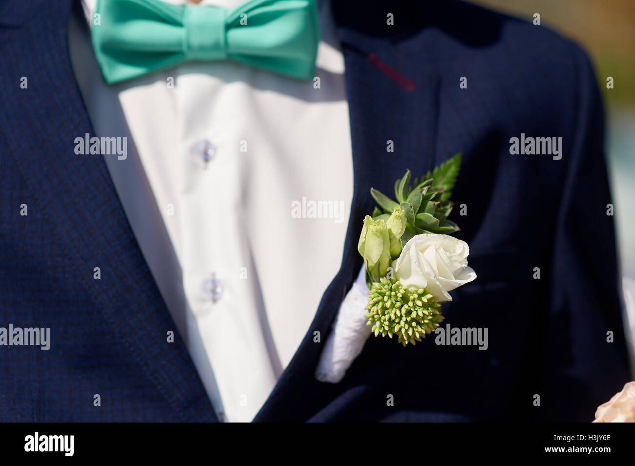 white wedding boutonniere on Groom's jacket Stock Photo
