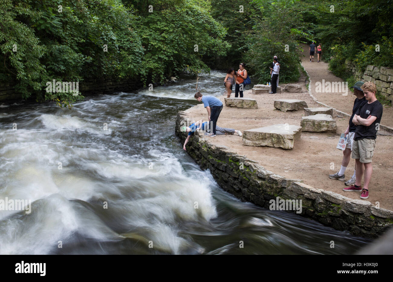 People look at the rushing current of the Minnehaha River near Minnehaha Falls in Minnesota Stock Photo