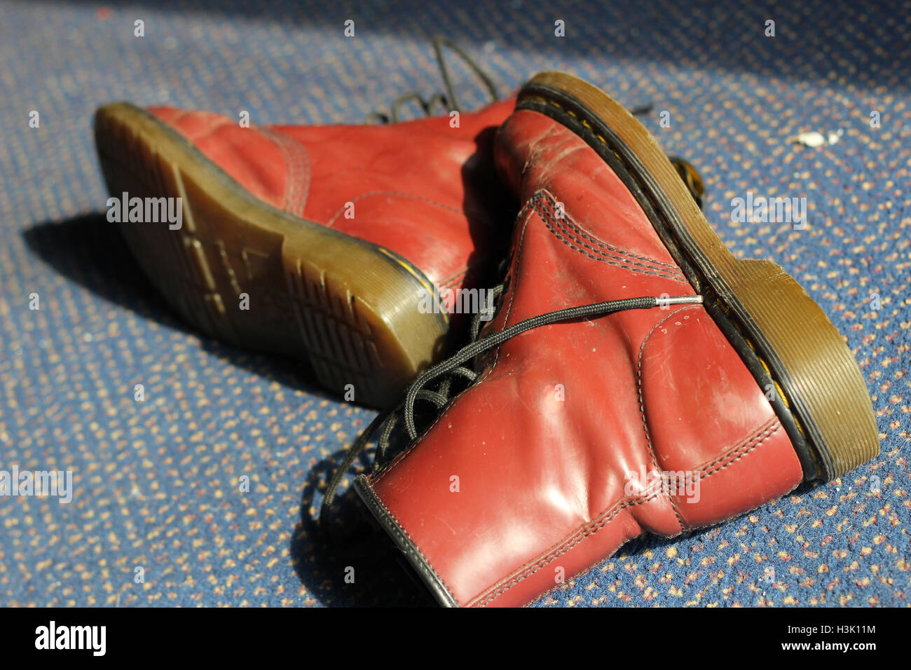 Cardiff, Wales. 22nd Sept, 2014. A pair of red, lace-up boots sits on carpet in sunlight. ©AimeeHerd Freelance Stock Photo