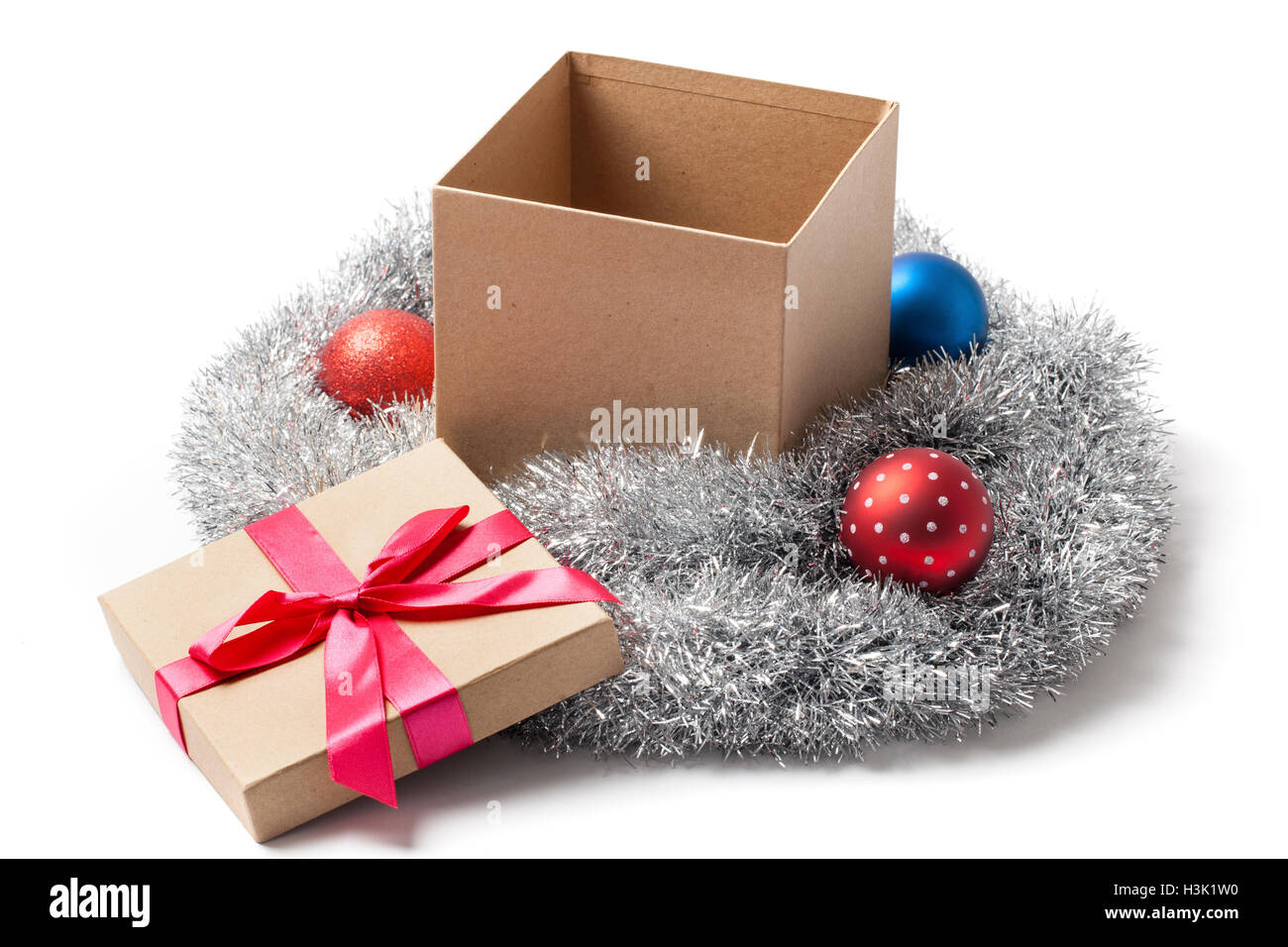 Open Christmas gift box tree balls and tinsels garland isolated on white. Stock Photo