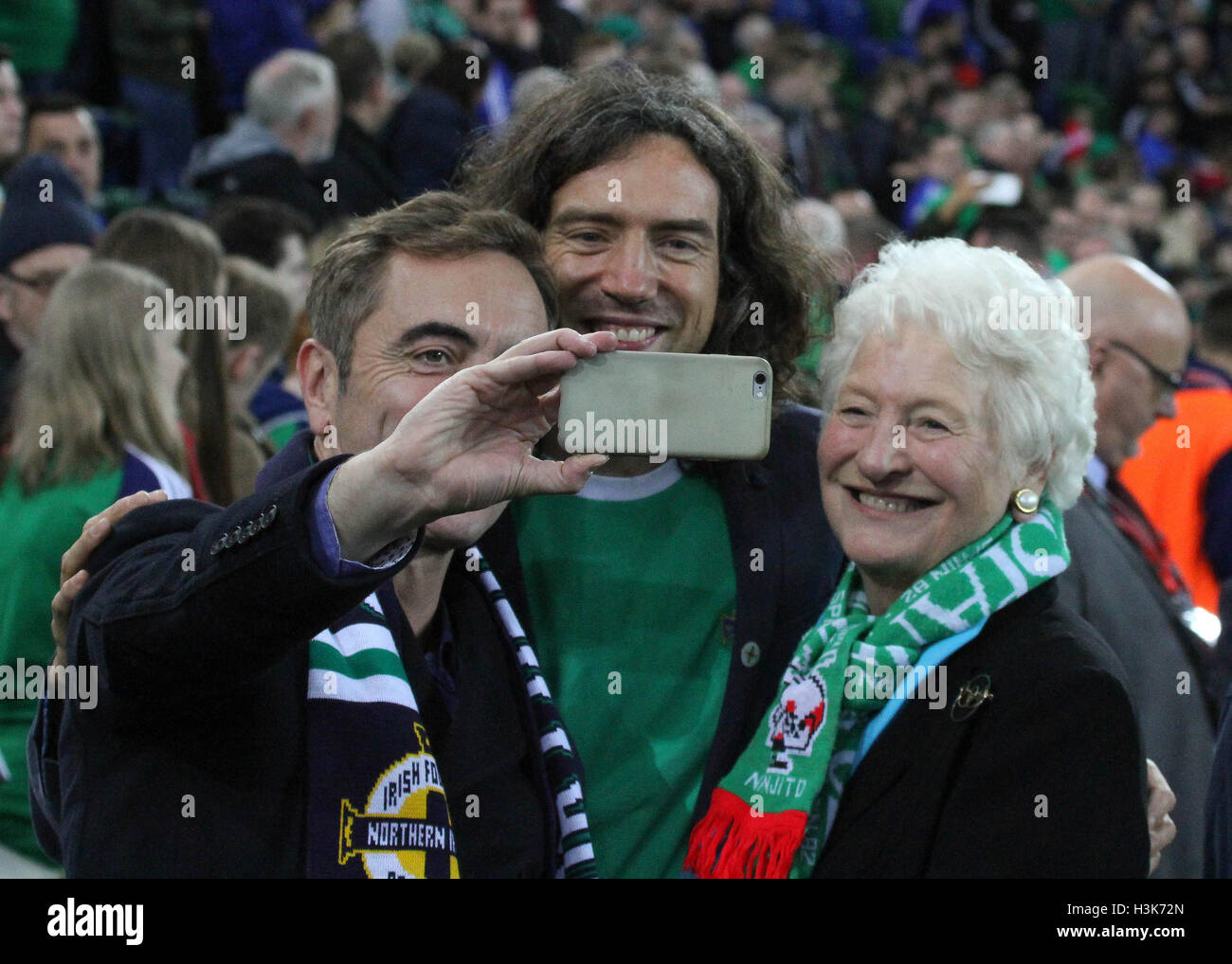 National Football Stadium at Windsor Park, Belfast, Northern Ireland.  08th October 2016. To mark the official opening of the National Football Stadium at Windsor Park in Belfast (the re-development of the old Windsor Park) a Lap of Northern Ireland Legends around the stadium took place. Selfie-time for (l-r) Actor Jimmy Nesbitt, Snow Patrol's Gary Lightbody and Dame Mary Peters at the event. David Hunter/Alamy Live News. Stock Photo