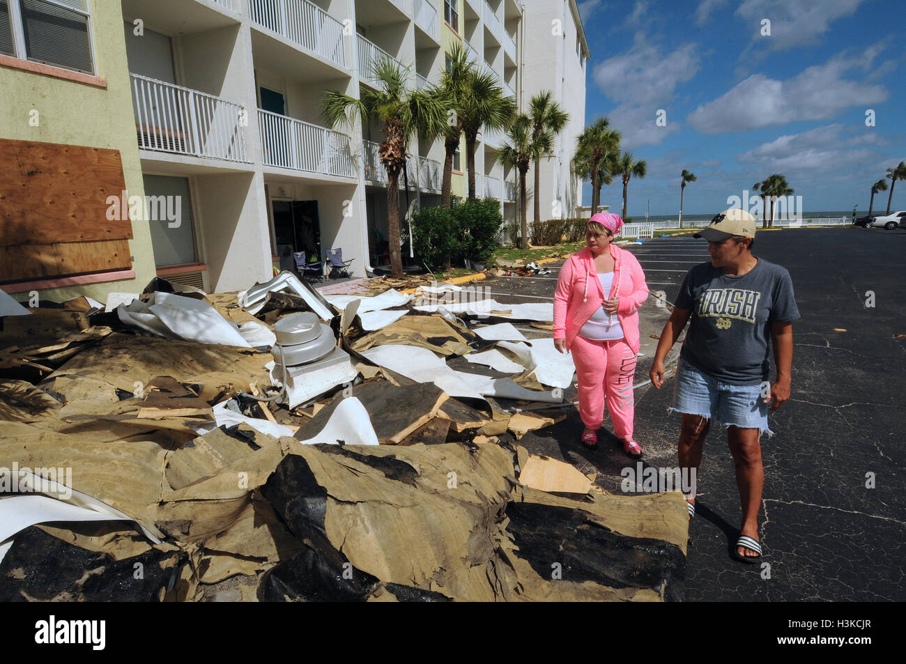 Daytona Beach, Florida, USA. 09th Oct, 2016. Jan Caputi (left) and her wife, Angela Caputi look at debris from their apartment building at the Ocean Jewels Resort two days after the resort was heavily damaged when the roof was ripped off on October 7, 2016 by Hurricane Matthew as the storm slammed Daytona Beach, Florida. The couple rode out the storm in a stairwell near their apartment. Their unit suffered water damage but is habitable. Matthew is one of the strongest hurricanes to ever batter the U.S. coast. Credit:  Paul Hennessy/Alamy Live News Stock Photo