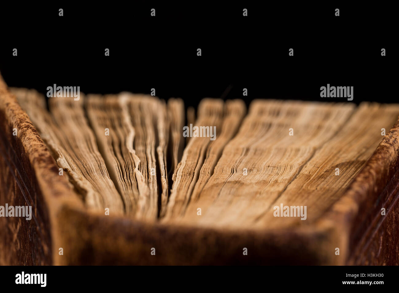ancient book shot on black background. The book is in bad condition ...
