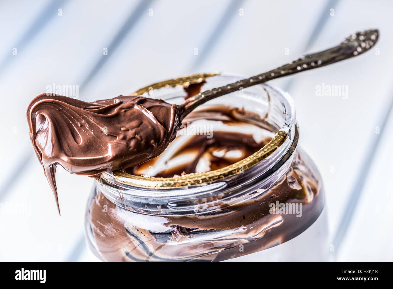 Chocolate spread in spoon. A jar of hazelnut chocolate spread. Stock Photo