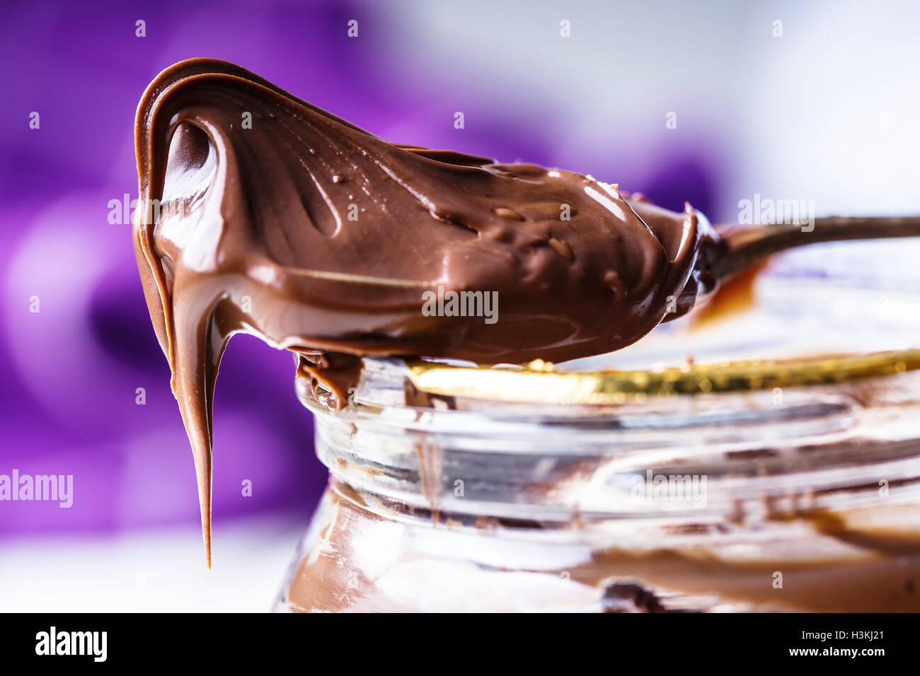 Chocolate spread in spoon. A jar of hazelnut chocolate spread. Stock Photo