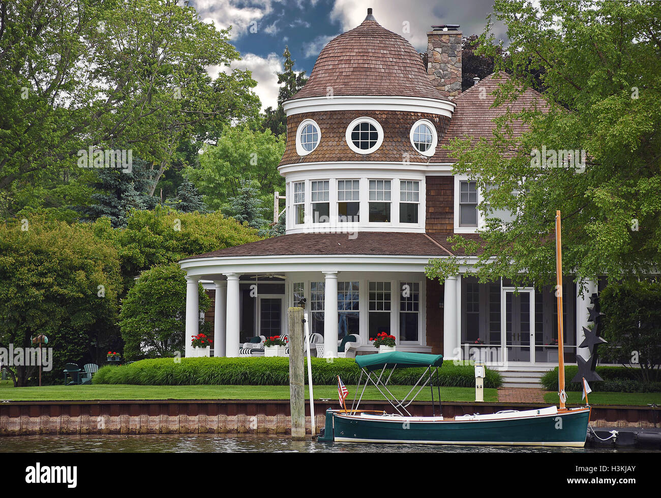 luxury summer home with boat on riverfront Stock Photo