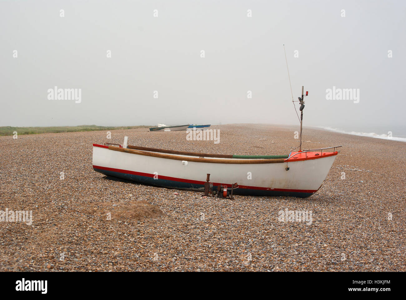 Small fishing boat on a pebble beach Stock Photo - Alamy