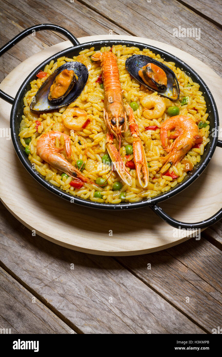 Spanish paella on a wooden table, portrait orientation Stock Photo