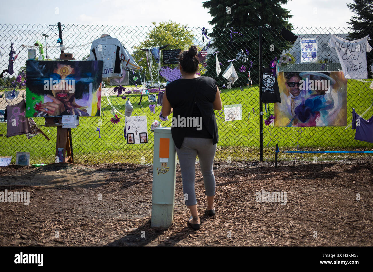 A woman looks at Prince memorabilia attached to a fence outside Paisley Park Studios in Chanhassen, Minnesota Stock Photo