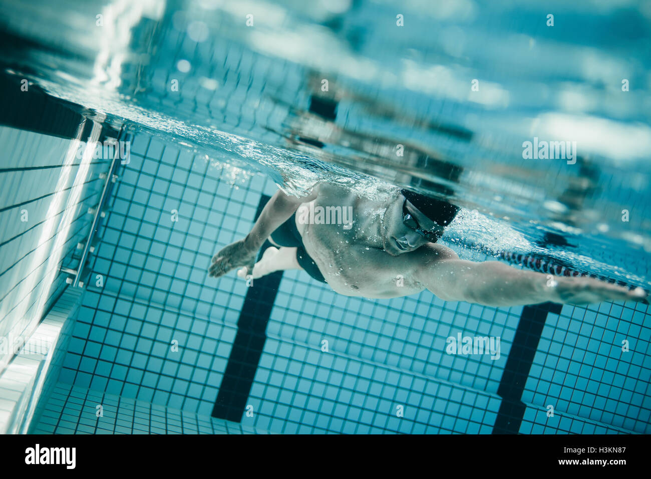Underwater shot of young sportsman swimming in pool.  Professional male swimmer inside swimming pool. Stock Photo