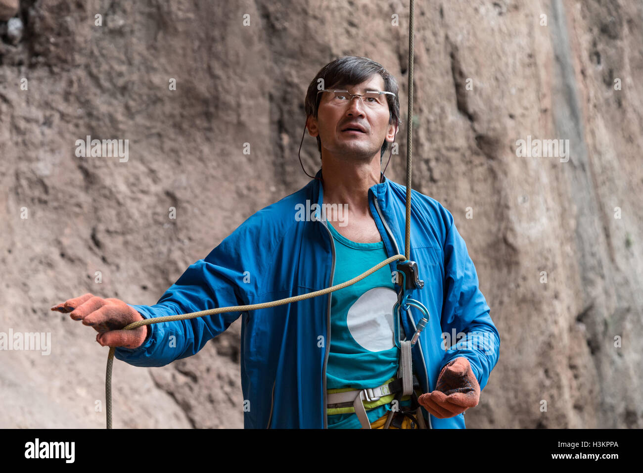 Athlete belays Climber using belaying device and rope Stock Photo