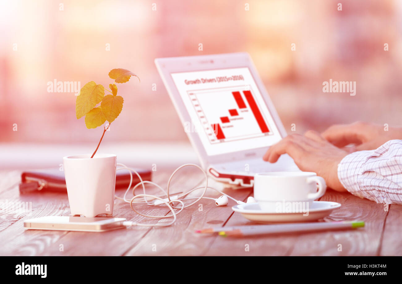 Workplace at Outdoor Patio at wooden Table with Computer and Flower