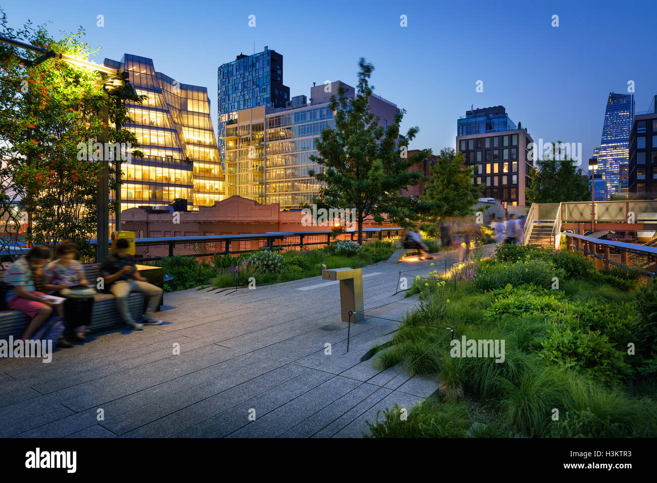 Twilight on the Highline (High Line Park) promenade in Chelsea with city lights. Manhattan, New York City Stock Photo