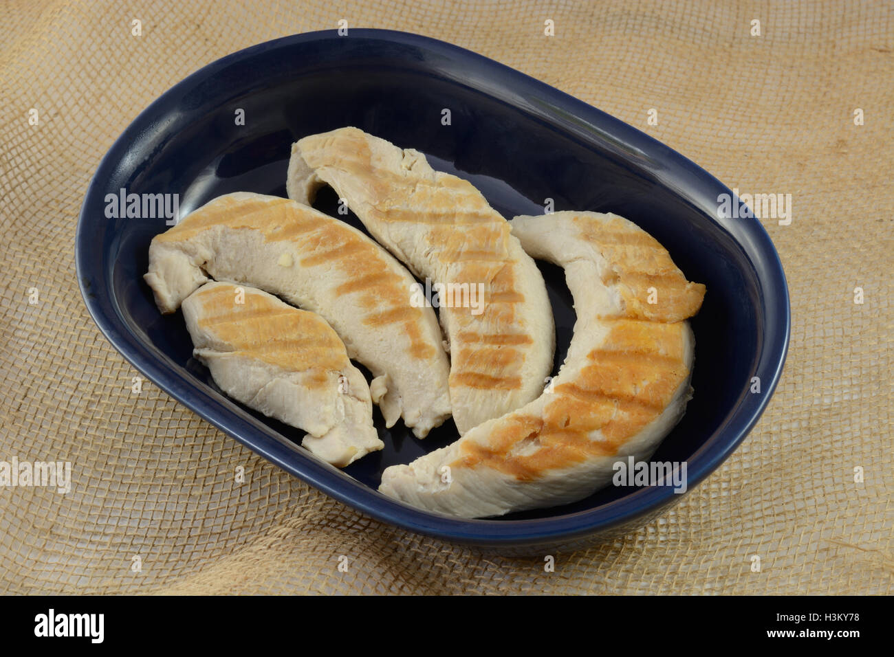 Grilled turkey tenderloin fillets in blue dish Stock Photo - Alamy