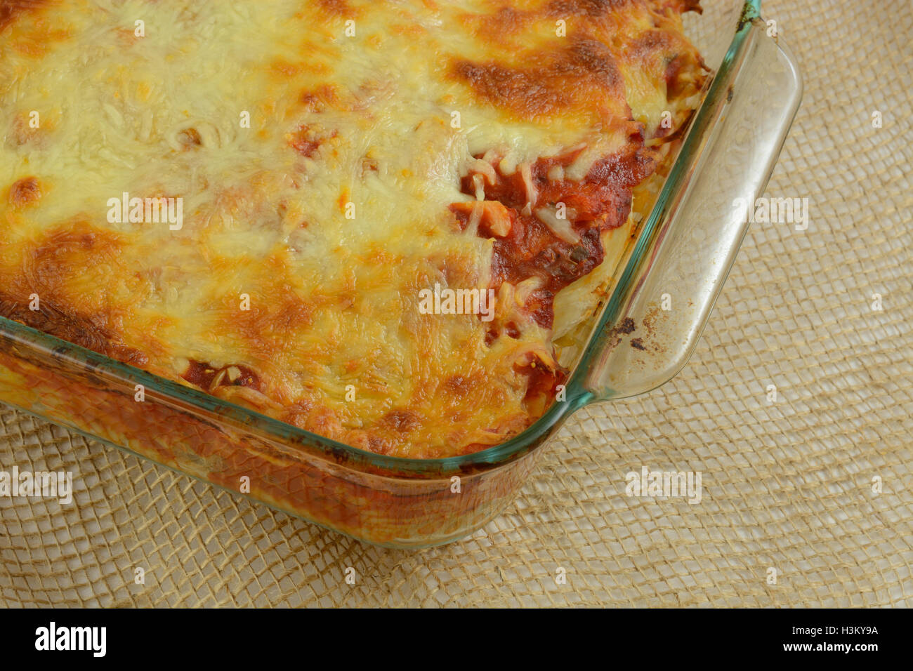 Close up of Casserole with pasta marinara sauce and melted cheese in glass baking dish Stock Photo