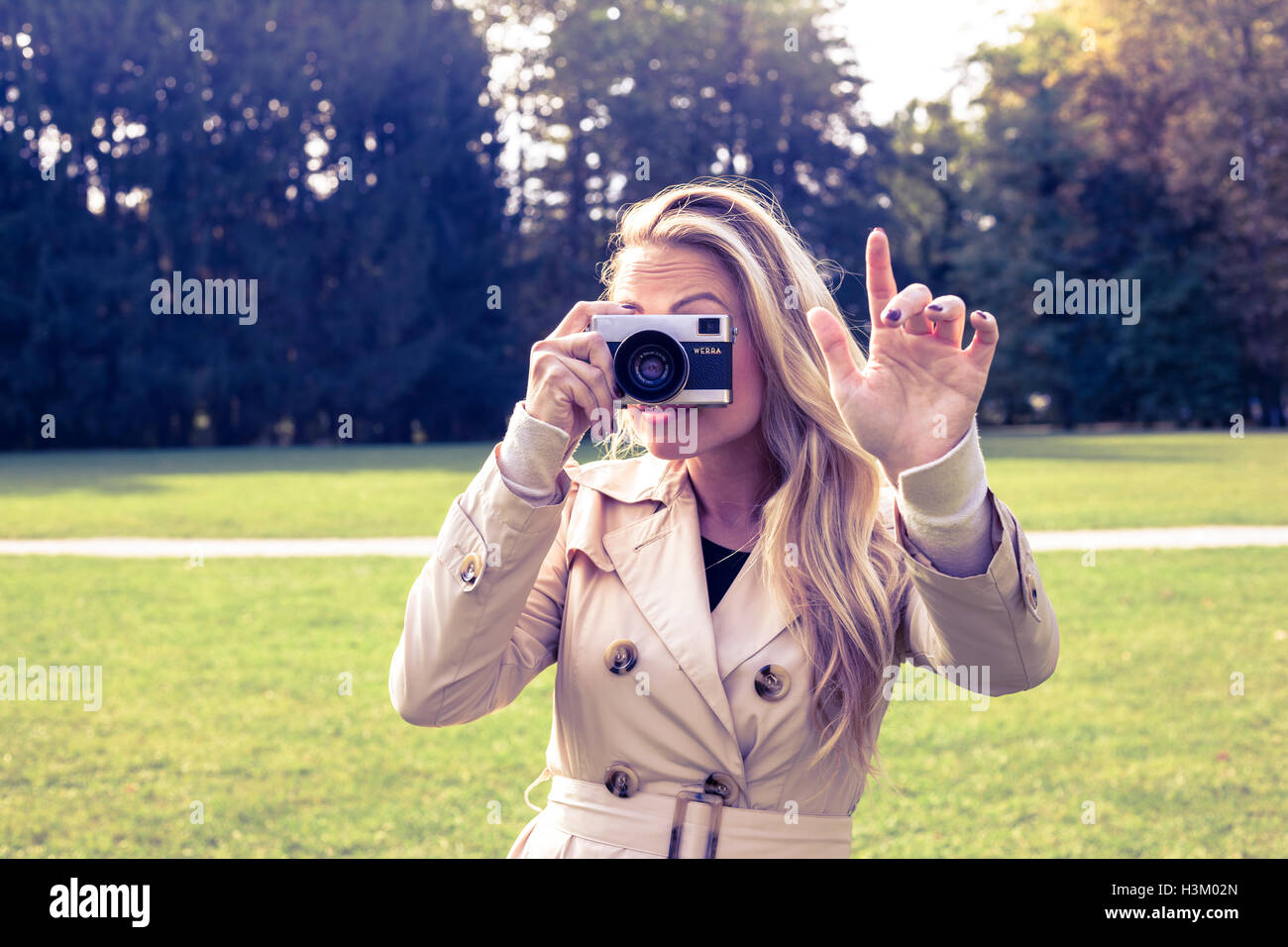 Attention, female is taking picture with old foto camera Stock Photo
