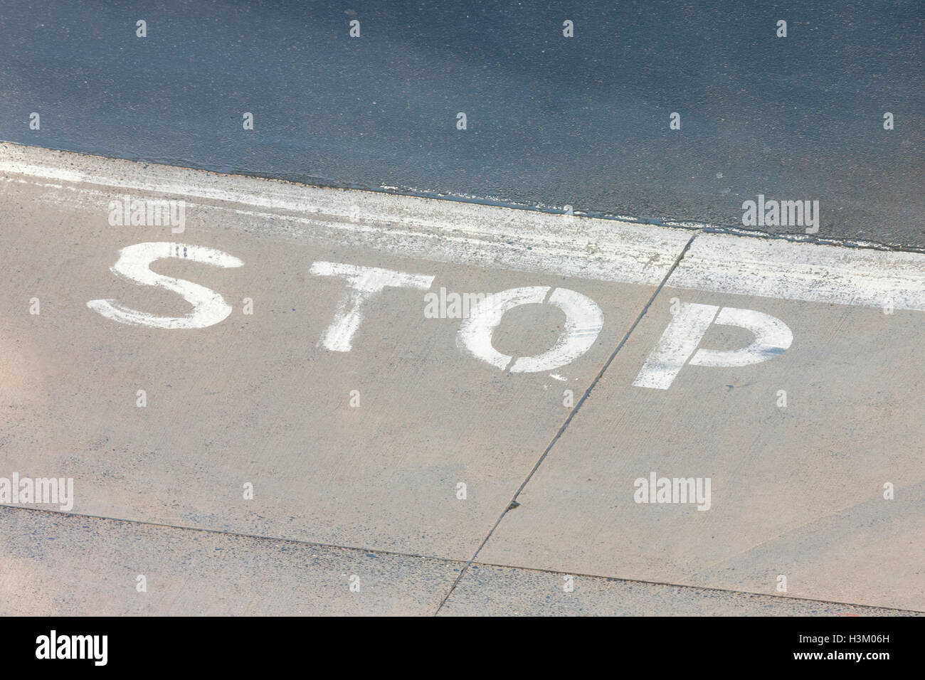word STOP painted on concrete ground Stock Photo