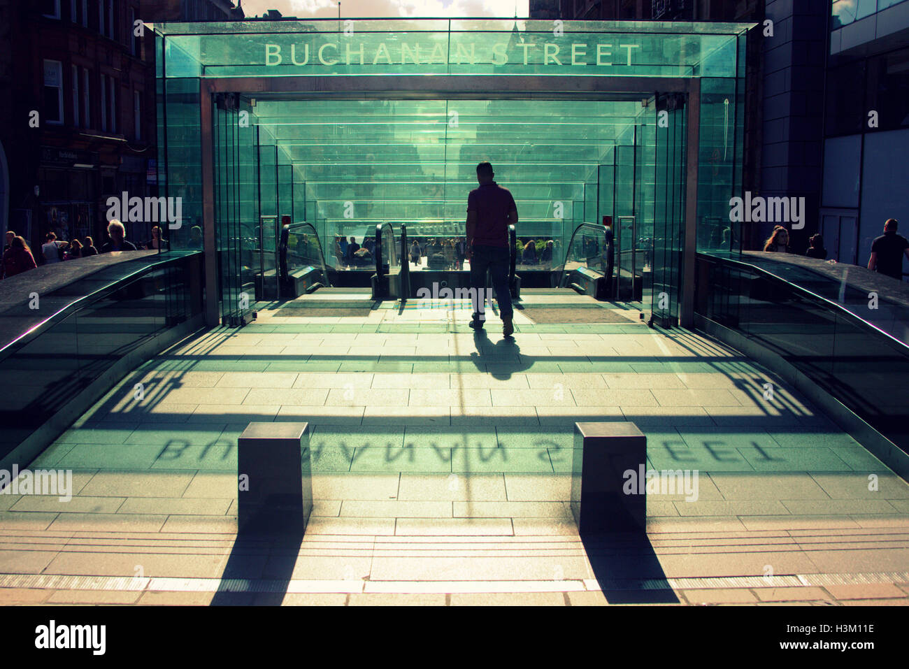 silhouettes of people in the city against the background of the entrance to Buchanan subway station Stock Photo