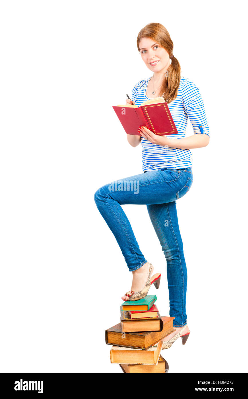 Beautiful female student with a pile of books Stock Photo - Alamy