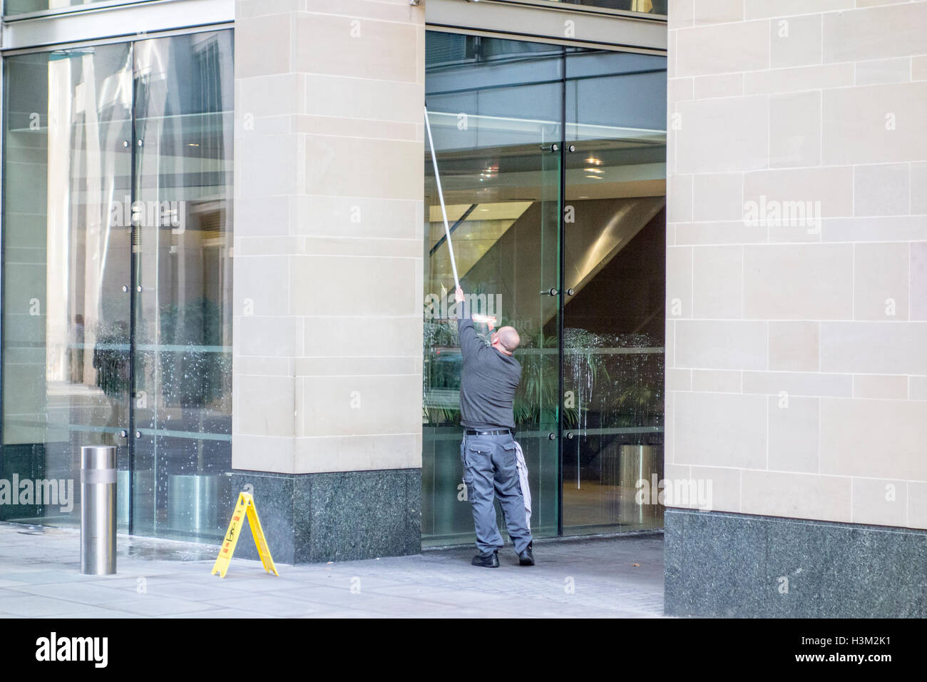 Window cleaner cleaning windows on an office building in London Stock Photo