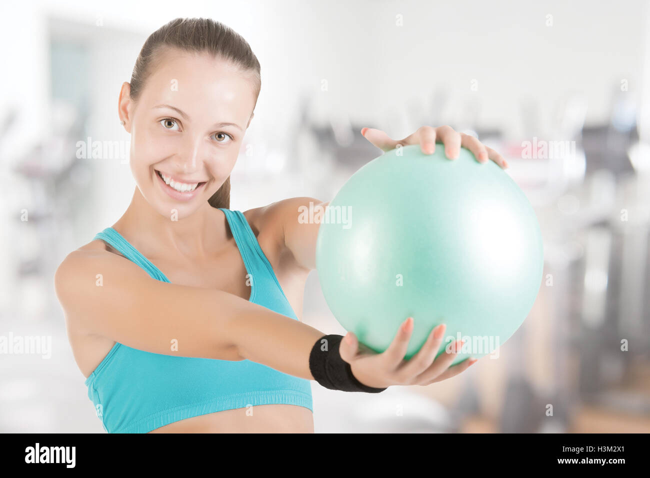 Fit woman standing and holding a pilates ball in a gym Stock Photo