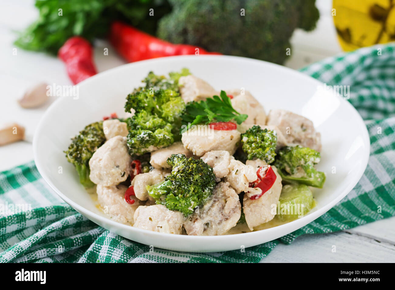 Delicate saute chicken with broccoli and chili peppers in a creamy garlic sauce Stock Photo